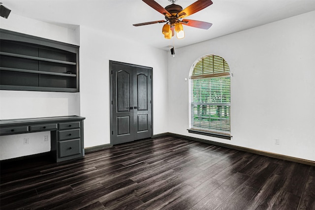 unfurnished living room featuring a ceiling fan, baseboards, and dark wood-type flooring