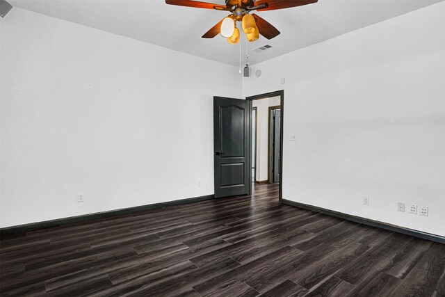 unfurnished room featuring ceiling fan, visible vents, baseboards, and dark wood-type flooring