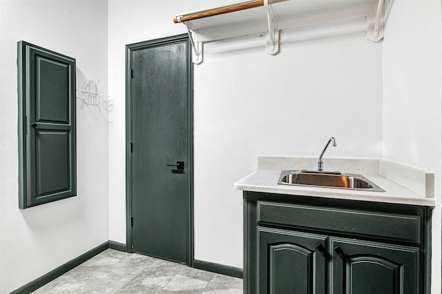 laundry room with a sink and baseboards