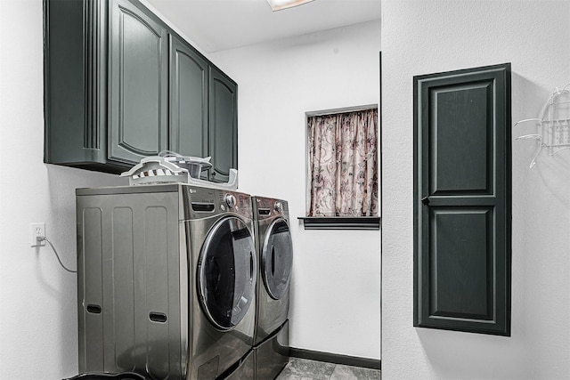 clothes washing area with separate washer and dryer, baseboards, and cabinet space
