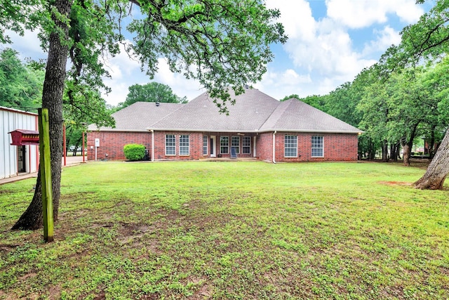 ranch-style home with brick siding, roof with shingles, and a front lawn