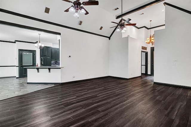 unfurnished living room featuring baseboards, ceiling fan with notable chandelier, and wood finished floors