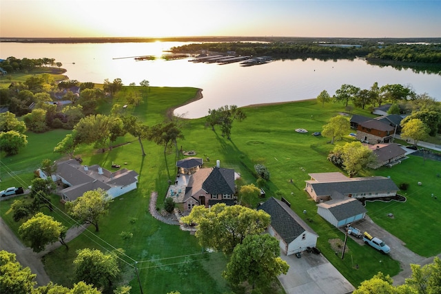 aerial view at dusk featuring a residential view and a water view