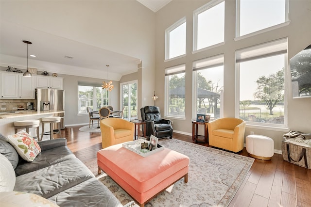 living area featuring an inviting chandelier, wood-type flooring, and a wealth of natural light
