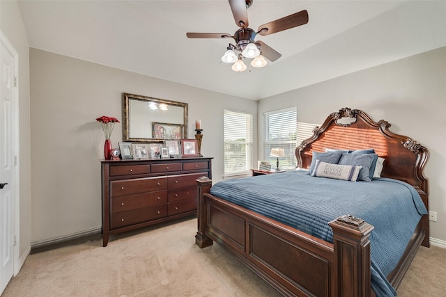 bedroom with baseboards, light colored carpet, ceiling fan, and vaulted ceiling