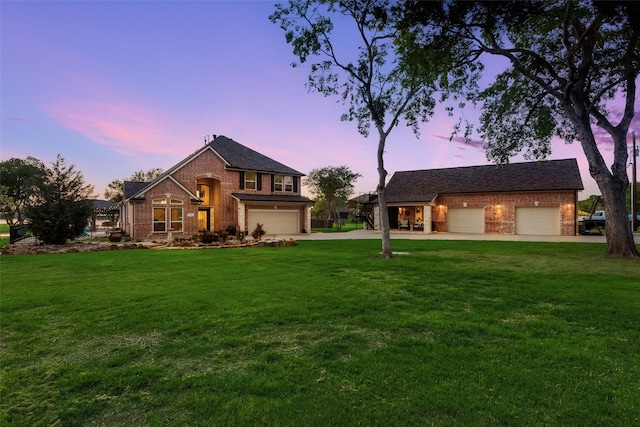 view of front of home featuring brick siding, driveway, and a front yard