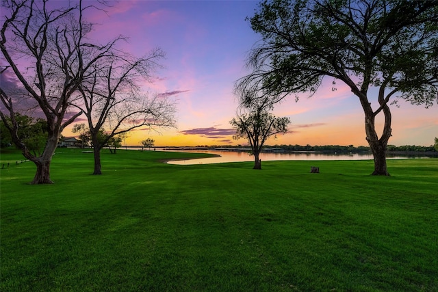 view of property's community with a lawn and a water view