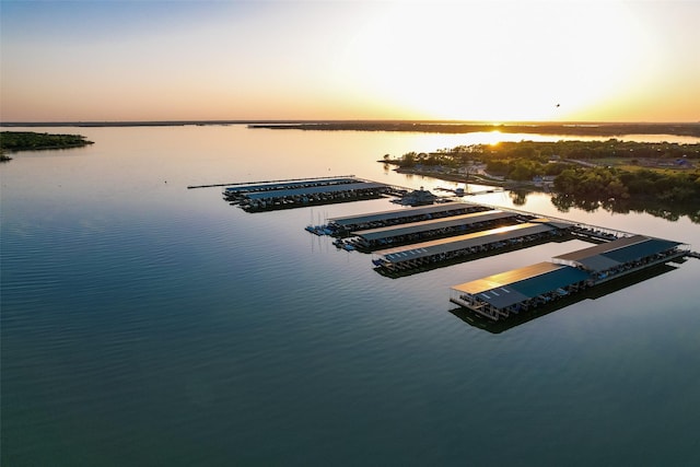 aerial view at dusk featuring a water view