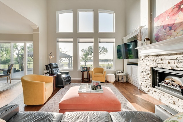 20065 Fiddlers Green Rd, Frisco, TX 75036 - living room with crown molding, a fireplace, wood finished floors, and a towering ceiling