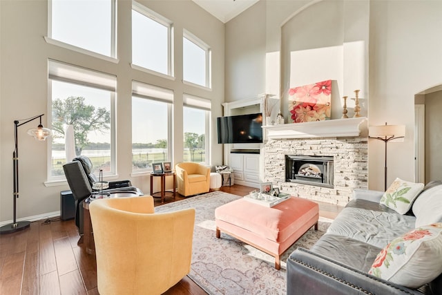 20065 Fiddlers Green Rd, Frisco, TX 75036 - living room featuring wood finished floors, healthy amount of natural light, a high ceiling, a fireplace, and arched walkways