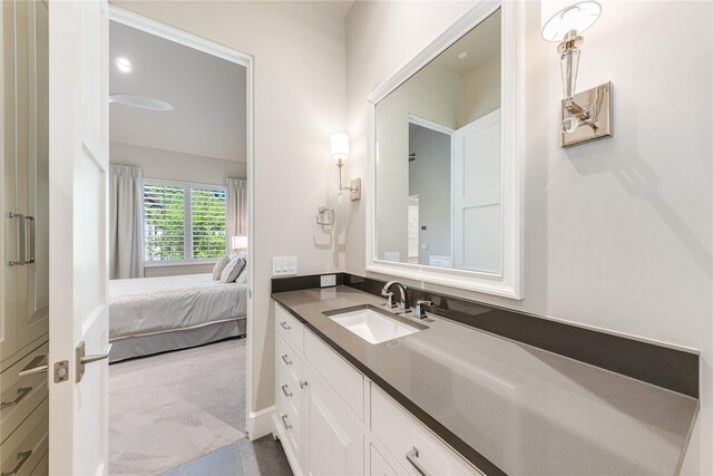 ensuite bathroom featuring vanity and connected bathroom
