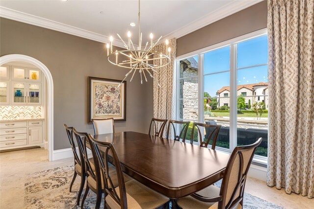 dining area featuring crown molding, a notable chandelier, and a wealth of natural light