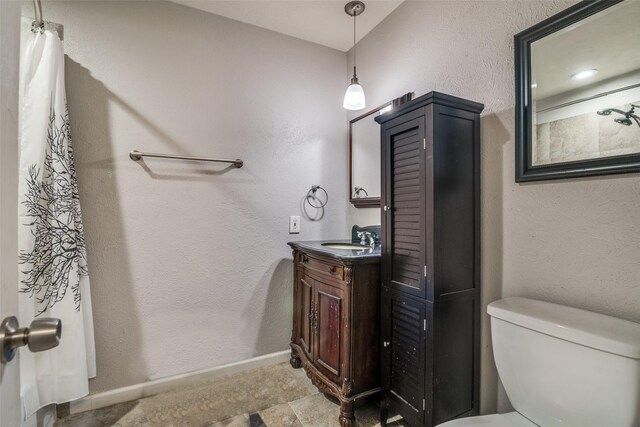 bathroom featuring toilet, baseboards, a shower with shower curtain, and vanity