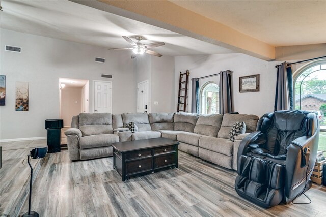 living room with visible vents, light wood-style floors, ceiling fan, and vaulted ceiling