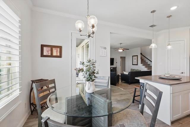 dining room with visible vents, crown molding, stairway, and light wood-type flooring