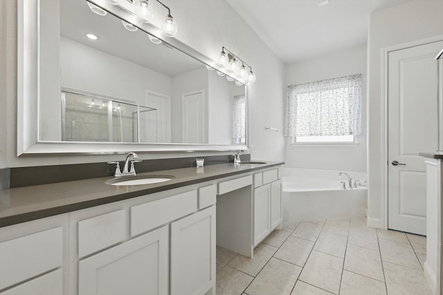 full bath featuring a garden tub, a sink, tile patterned flooring, and double vanity