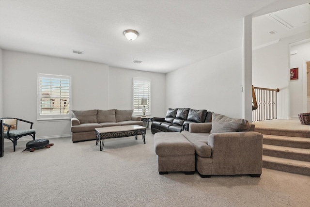 carpeted living area featuring visible vents and baseboards