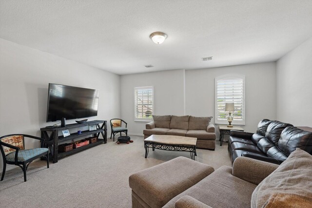 living area with visible vents and light carpet