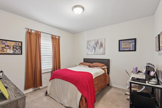 bedroom featuring baseboards and light carpet