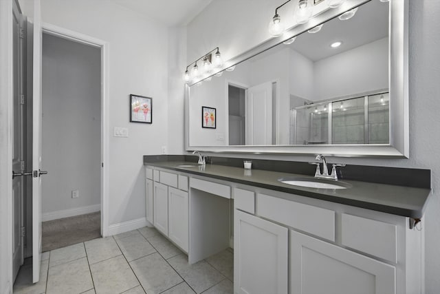 bathroom featuring a sink, tile patterned floors, a shower stall, and double vanity