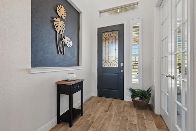 foyer entrance with baseboards and wood finished floors