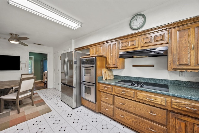 9008 Flicker Ln, Dallas, TX 75238 - kitchen featuring stainless steel appliances, under cabinet range hood, brown cabinets, and dark countertops