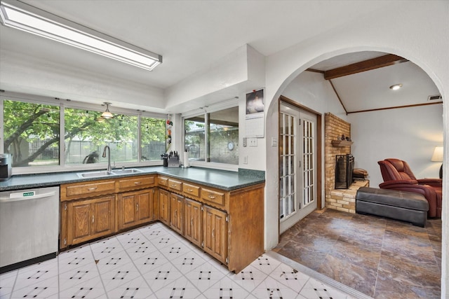9008 Flicker Ln, Dallas, TX 75238 - kitchen featuring dishwasher, a sink, brown cabinets, dark countertops, and arched walkways