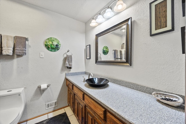 9008 Flicker Ln, Dallas, TX 75238 - bathroom featuring tile patterned floors, toilet, vanity, and baseboards