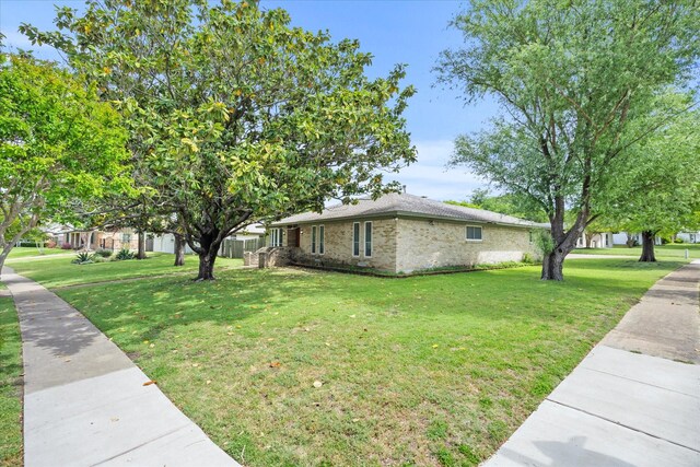 9008 Flicker Ln, Dallas, TX 75238 - view of home's exterior with a lawn and brick siding