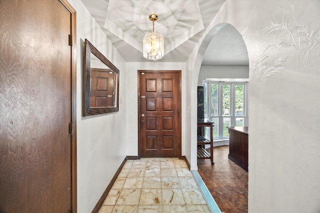 9008 Flicker Ln, Dallas, TX 75238 - foyer entrance with arched walkways, baseboards, light marble finish floors, and a chandelier