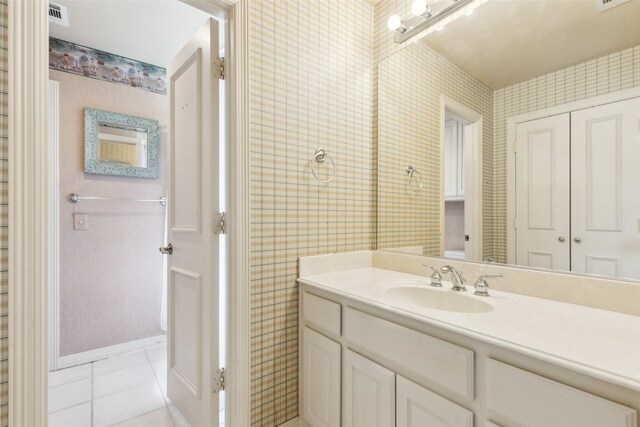 bathroom with vanity, tile patterned flooring, wallpapered walls, and visible vents