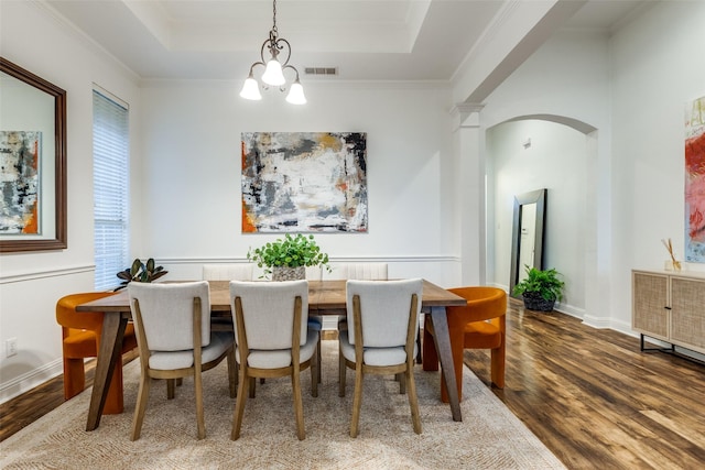5000 Stonecrest Dr, Mckinney, TX 75071 - dining area featuring wood finished floors, a chandelier, a raised ceiling, arched walkways, and baseboards