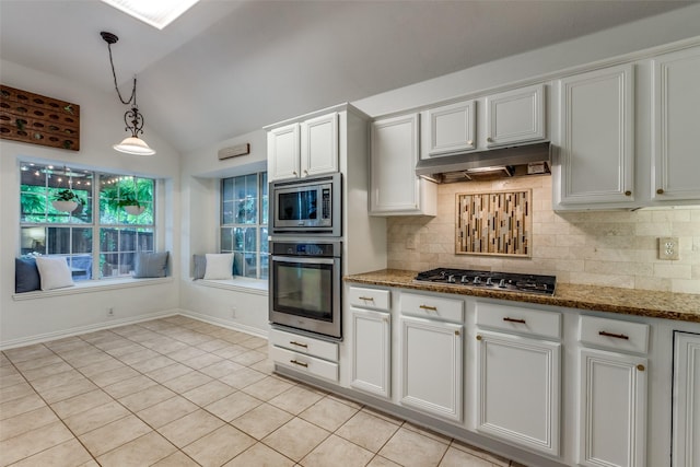 5000 Stonecrest Dr, Mckinney, TX 75071 - kitchen featuring stainless steel appliances, vaulted ceiling, under cabinet range hood, light tile patterned flooring, and backsplash