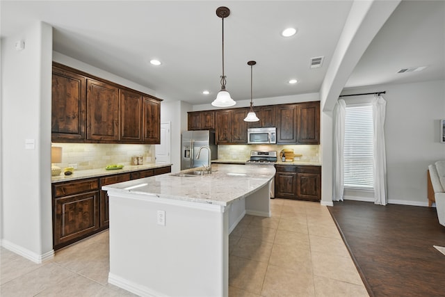 400 Sterling Rdg, Lantana, TX 76226 - kitchen featuring light tile patterned floors, stainless steel appliances, dark brown cabinets, and a sink