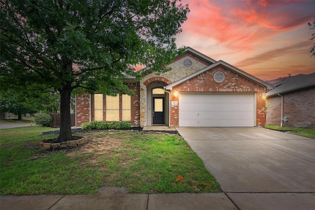 view of front of property featuring a front lawn, stone siding, a garage, brick siding, and driveway