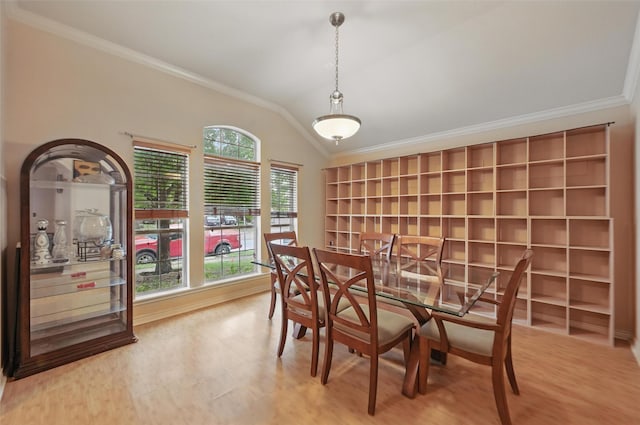 dining space with built in features, ornamental molding, wood finished floors, and lofted ceiling
