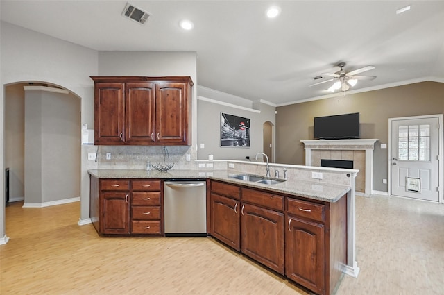 kitchen with a sink, arched walkways, a ceiling fan, a peninsula, and stainless steel dishwasher