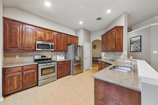kitchen featuring visible vents, appliances with stainless steel finishes, arched walkways, a sink, and a peninsula