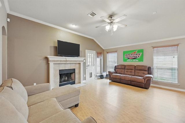 living area with visible vents, ornamental molding, wood finished floors, ceiling fan, and vaulted ceiling