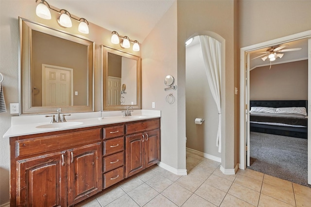 ensuite bathroom with a sink, tile patterned flooring, a ceiling fan, and double vanity