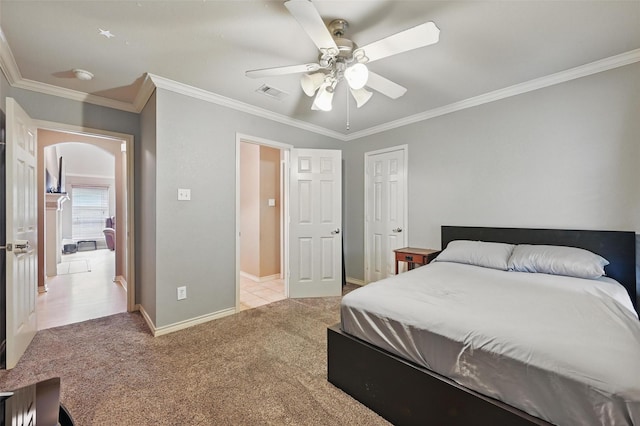 carpeted bedroom featuring crown molding, arched walkways, and visible vents