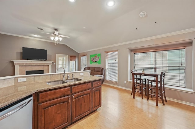 kitchen with ceiling fan, a sink, open floor plan, dishwashing machine, and ornamental molding