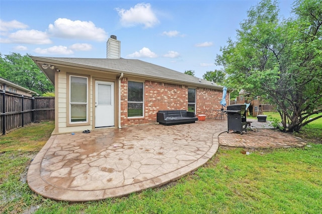 rear view of house featuring brick siding, a fenced backyard, a patio area, and a yard