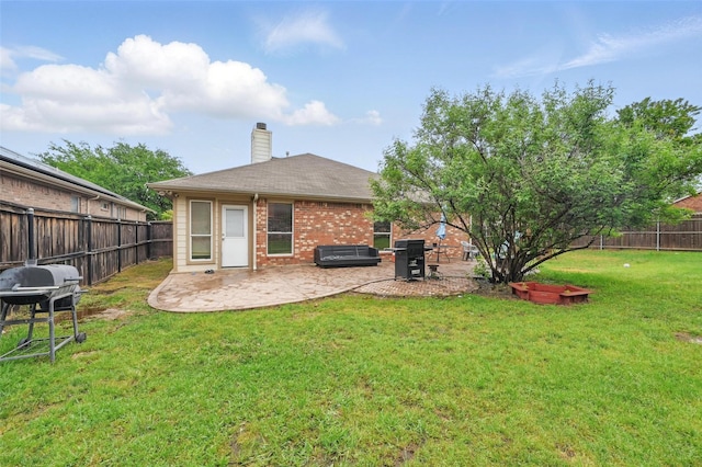 rear view of house with a lawn, a fenced backyard, a patio area, and brick siding