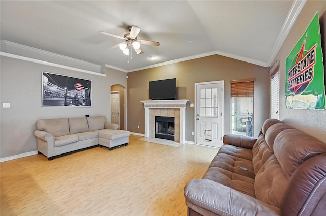 living area featuring arched walkways, ceiling fan, ornamental molding, and wood finished floors