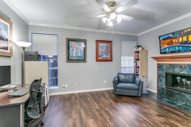 office space featuring ceiling fan, a fireplace, a textured ceiling, baseboards, and wood finished floors