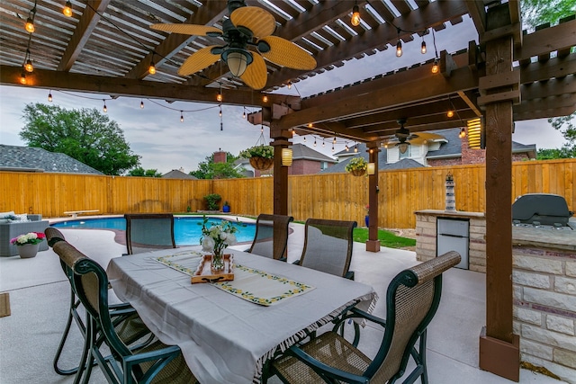 view of patio / terrace with grilling area, exterior kitchen, fence, and a ceiling fan