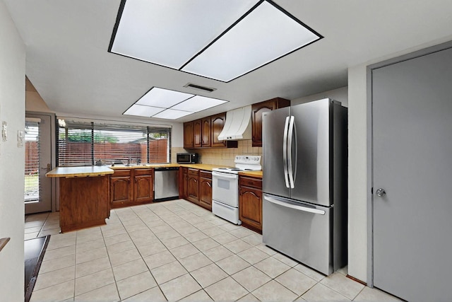 1907 Rambling Ridge Ln, Carrollton, TX 75007 - kitchen with light countertops, stainless steel appliances, light tile patterned floors, and ventilation hood