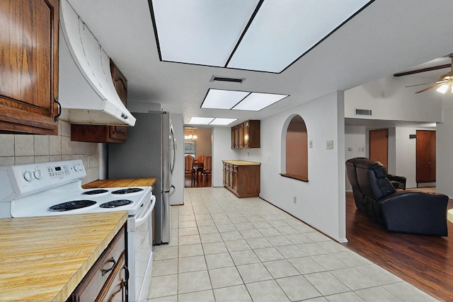 1907 Rambling Ridge Ln, Carrollton, TX 75007 - kitchen with backsplash, electric range, light tile patterned floors, and range hood