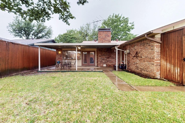 1907 Rambling Ridge Ln, Carrollton, TX 75007 - rear view of house featuring a fenced backyard, french doors, a chimney, brick siding, and a yard